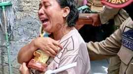 Sambil menangis, korban penggusuran di Jalan Irian Jaya, Else de Hoog keluar dari rumahnya dengan memeluk erat patung Bunda Maria/Foto : RakyatFlores.com