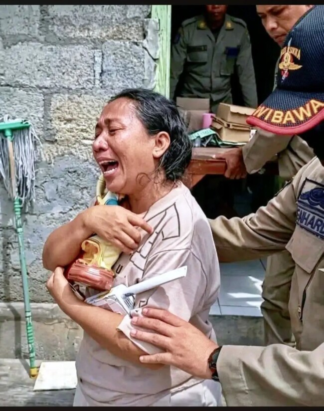 Sambil menangis, korban penggusuran di Jalan Irian Jaya, Else de Hoog keluar dari rumahnya dengan memeluk erat patung Bunda Maria/Foto : RakyatFlores.com