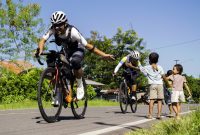 Ultra cyclist sejenak terhibur oleh keramahan anak-anak di tengah upaya taklukkan tanjakan terjal di pulau Flores.