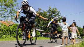 Ultra cyclist sejenak terhibur oleh keramahan anak-anak di tengah upaya taklukkan tanjakan terjal di pulau Flores.