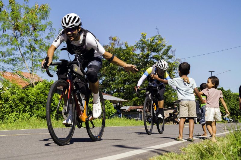 Ultra cyclist sejenak terhibur oleh keramahan anak-anak di tengah upaya taklukkan tanjakan terjal di pulau Flores.